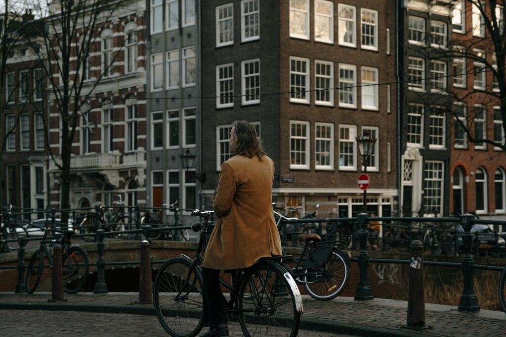 A person on a bicycle looks at buildings.